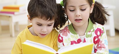 2 Children reading a book together